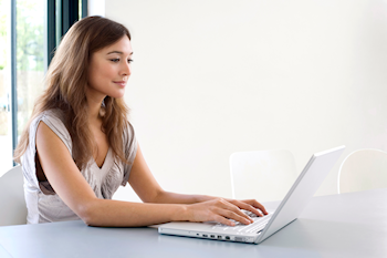 female business professional typing on a laptop