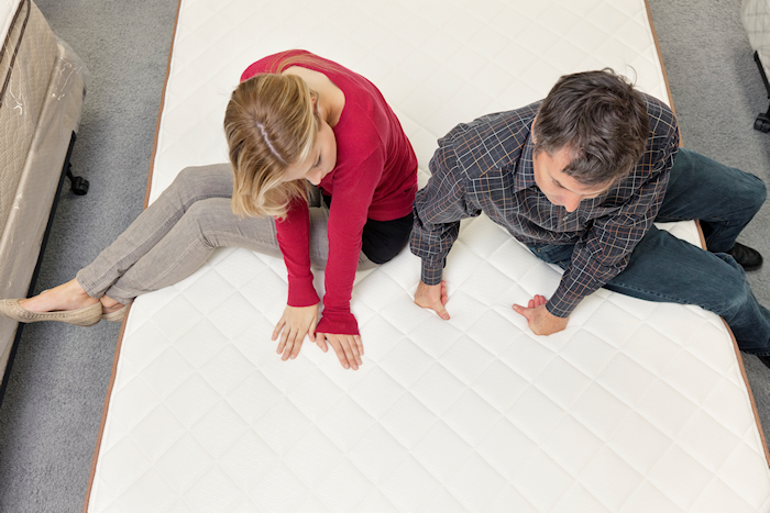 Couple both sitting on a mattress