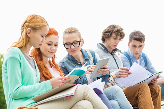 Students studying wiht pen, paper, and tablets