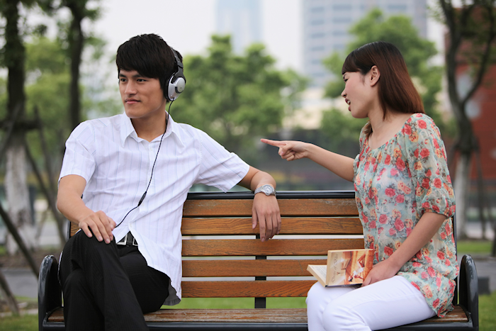 Man ignoring woman while wearing headphones