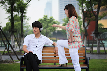 Man ignoring woman while wearing headphones